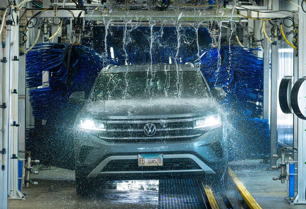 A vehicle moving through the Clearwave Alsip wash tunnel under the soft-foam brushes