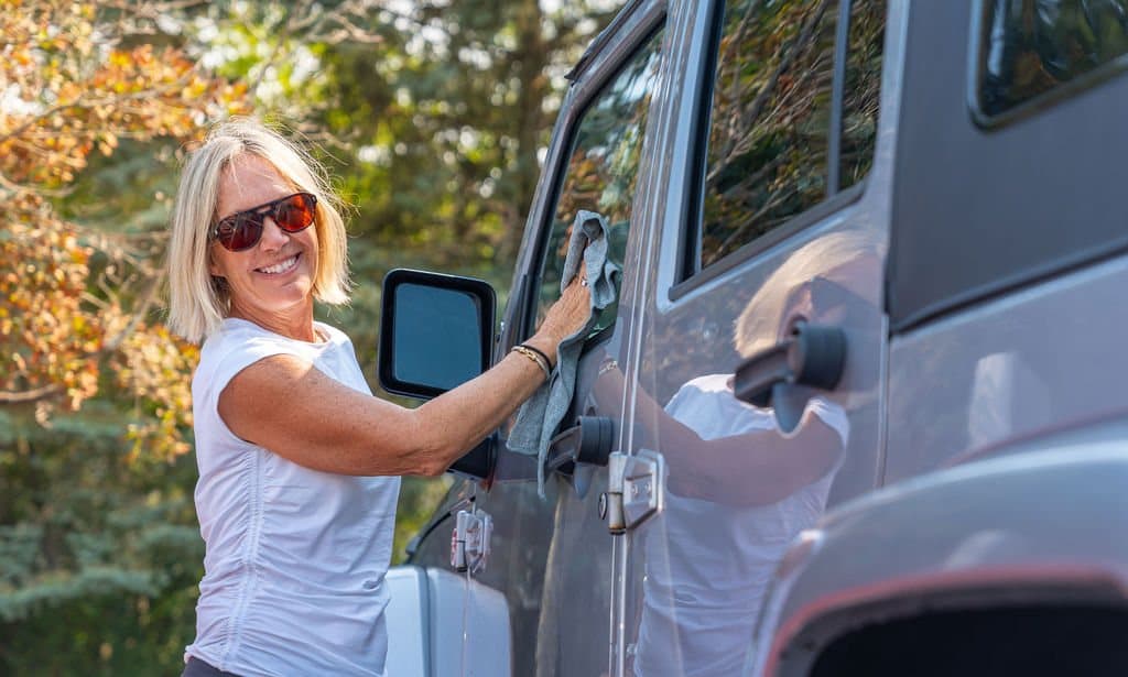 A Standard Wash team member hand-detailing a vehicle