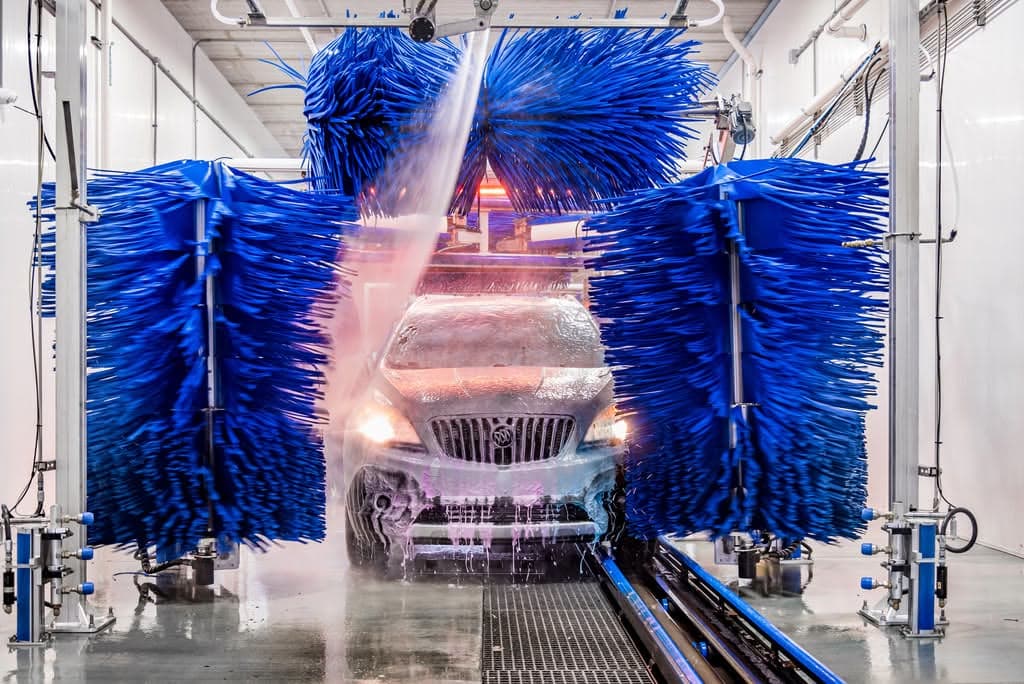 A car moving through Clearwave's blue soft-foam wash brushes